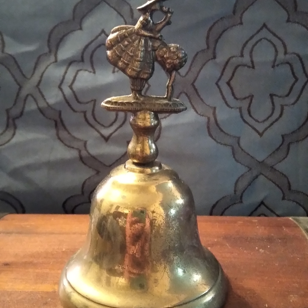 Vintage brass bell girl smelling the flowers